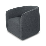The Evita Swivel Chair in slate grey boucle. Its low profile makes it ideal for placement in a bedroom corner, a cozy reading nook, or as the perfect complement to your living room seating. Crafted in Europe and upholstered in a luxe boucle fabric, this barrel chair not only exudes sophistication but also boasts a hidden swivel base, allowing for subtle rotations around the room. Experience both style and functionality with this chic swivel chair designed to elevate the ambiance of any space in your home.