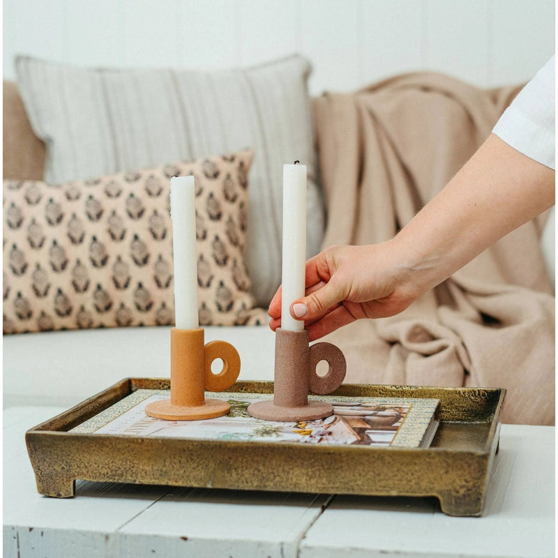 The Cruz Candle Holder is characterized by a contemporary shape and balanced with earthy texture and warm hued colours. Style it layered atop a decorative tray, books, or alone for a more minimal look. Complete it with a tapered candle for an inviting feel you will treasure year round.